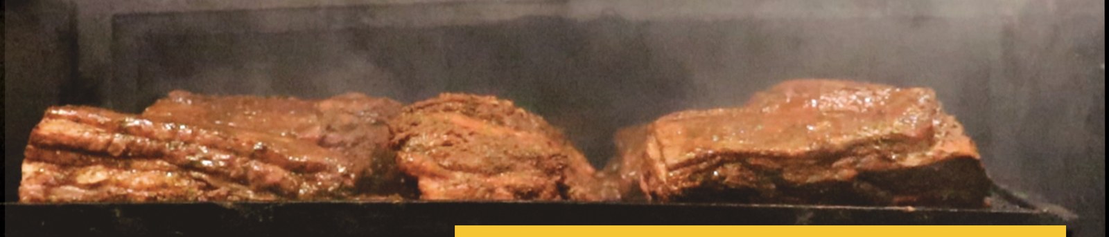Peças de carne defumando dentro do pit smoker do Art Chopp